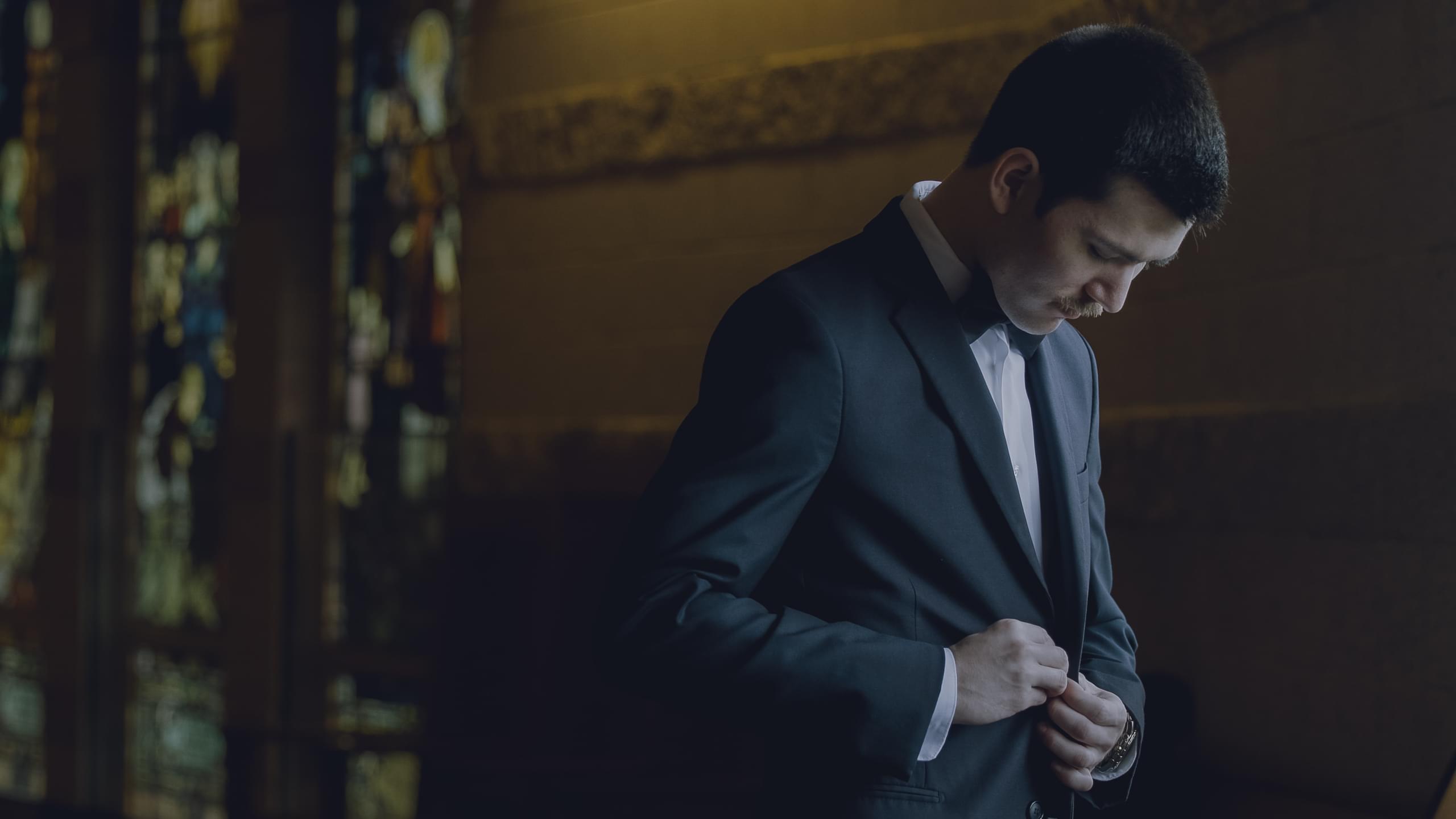 Aaron adjusting his suit jacket at their Duluth wedding ceremony location.