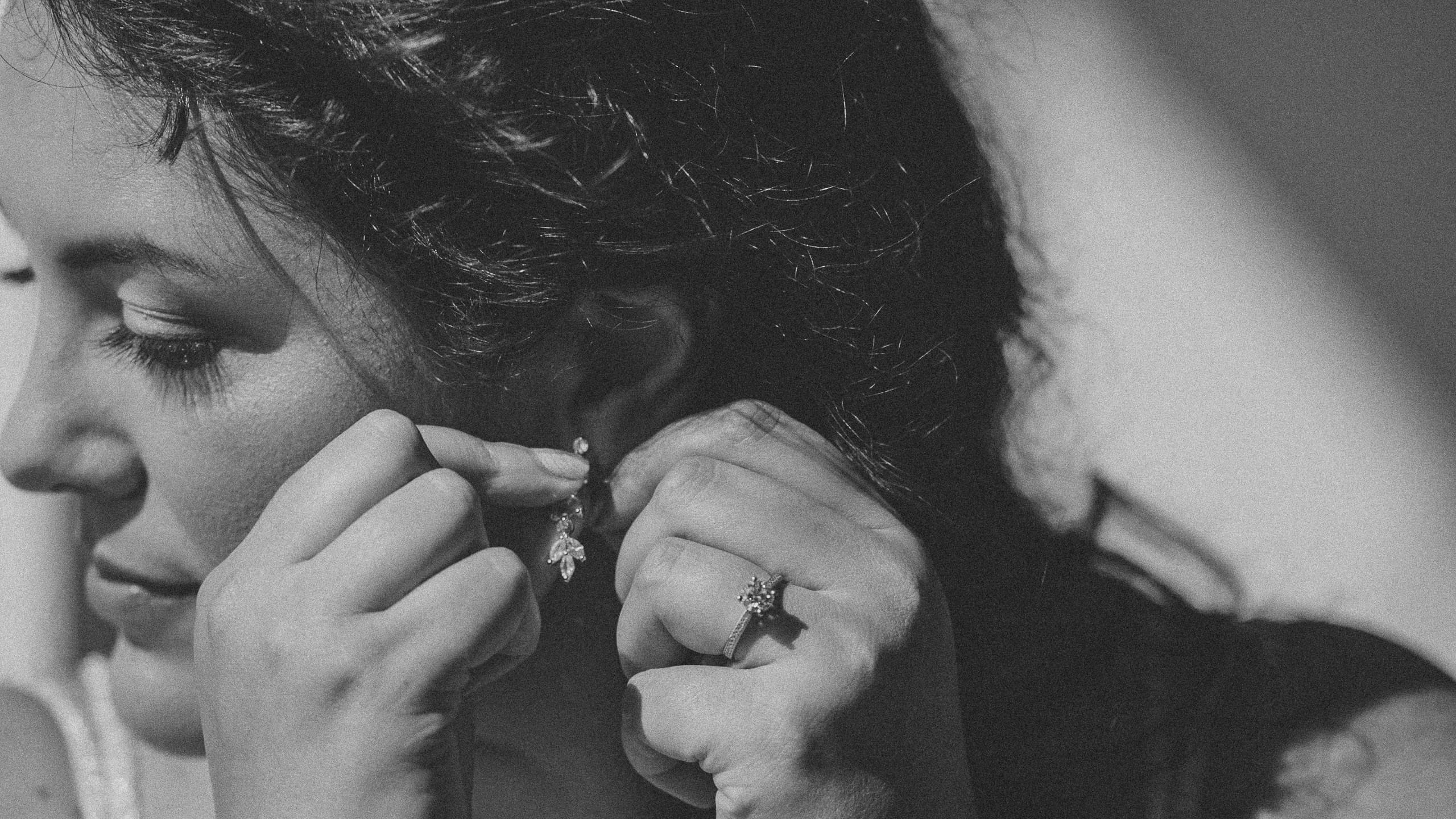 The bridge Melissa putting on her earrings for her Duluth wedding at The Garden