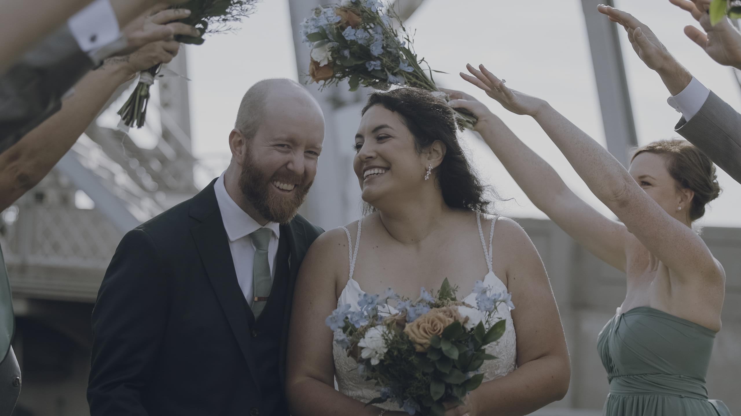 Melissa and Ryan walking through their party tunnel smiling on the Lakewalk in Duluth
